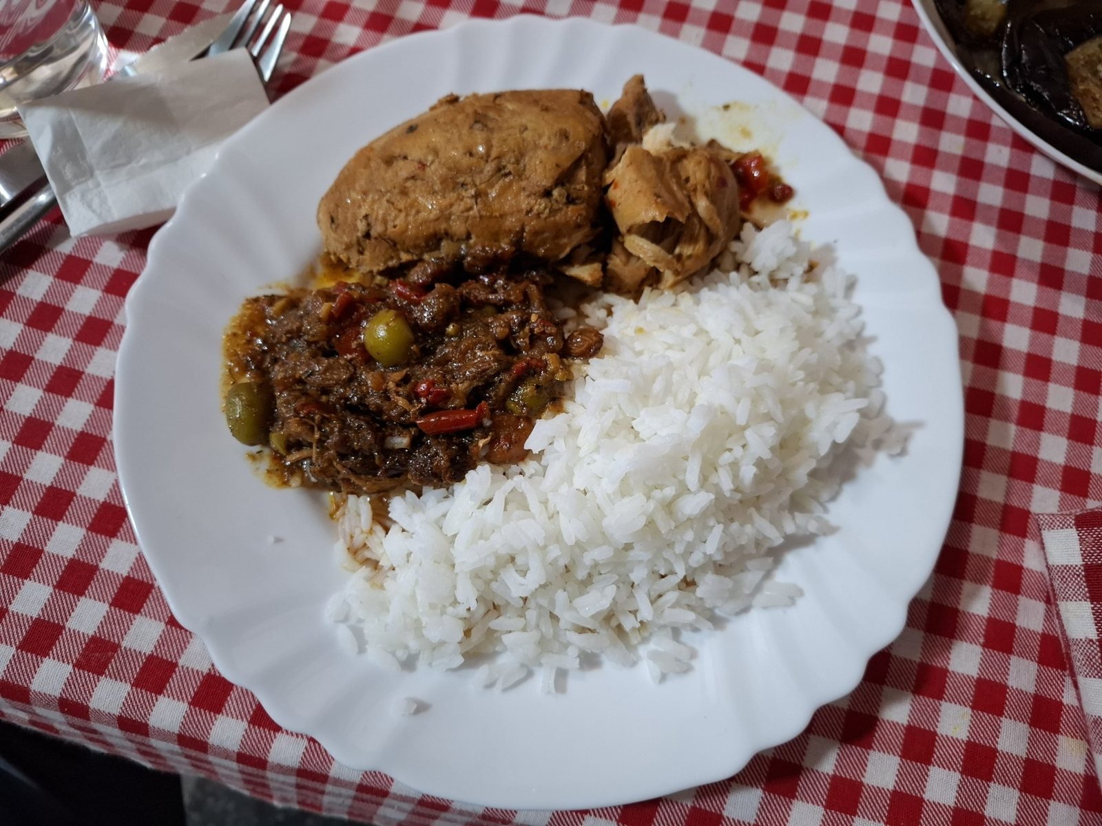 A plate of slow-stewed meat served with rice